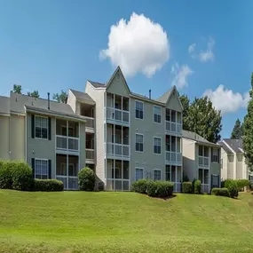 Three story apartment building surrounded by mature landscaping