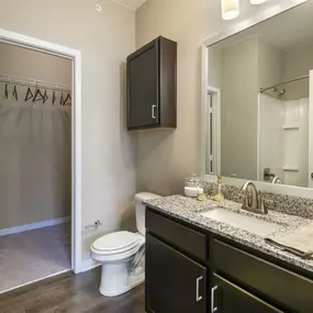 Bathroom with a large mirror and a toilet sink