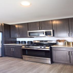 A kitchen with dark cabinets and stainless steel appliances