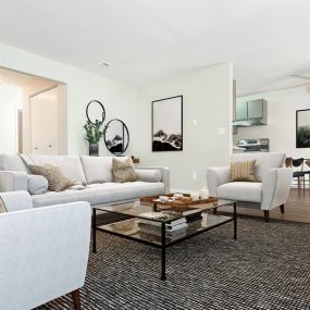 a spacious living room with white couches and chairs
