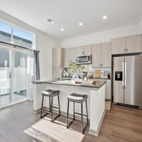 Kitchen with stainless steel appliances and an island with two stools