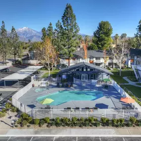 an aerial view of a resort style pool with a pool house in the background