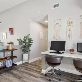 a room with a desk and two computer monitors