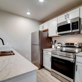 a kitchen with white cabinets and stainless steel appliances