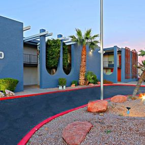 The driveway up to Allora Phoenix with Gravel Area containing large decorative rocks and a flag pole