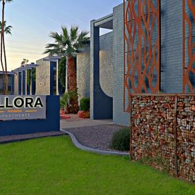 Allora Phoenix Welcome Sign with Manicured Landscaping and Grey Brick Building