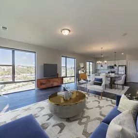 A large living room with blue couches and a table