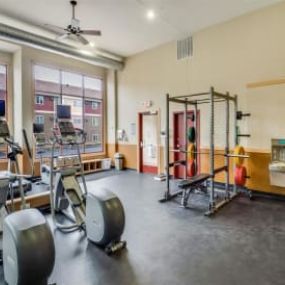 The gym with weights and equipment in a room with windows