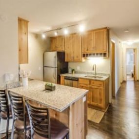 The kitchen with a marble counter top and wooden cabinets