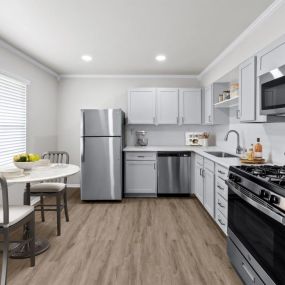 A kitchen with white cabinetry and stainless steel appliances