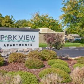 A sign that says Park View Apartments with trees in the background