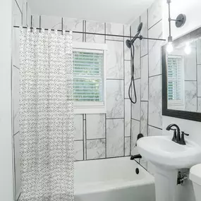 a white bathroom with a shower and a sink