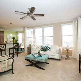 open concept living room with plush carpeting and large windows