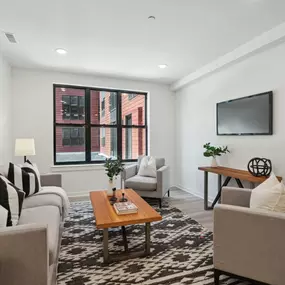 A living room with white walls and a large window