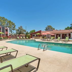 Green Chaise Lounge Chairs facing an Angled Pool