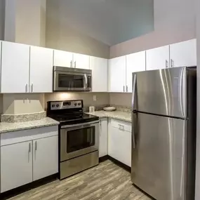 a kitchen with stainless steel appliances and white cabinets