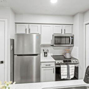 a kitchen with white cabinets and a white countertop