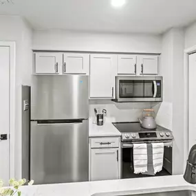 a kitchen with white cabinets and a white countertop