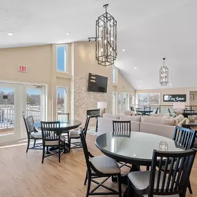 A dining area with a glass table surrounded by chairs.