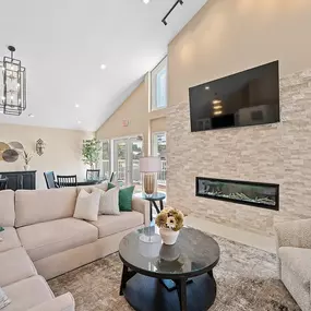 A living room with a fireplace and a flat screen TV mounted on the wall.