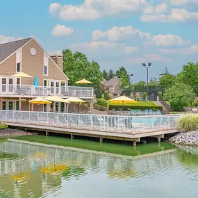 A house on the water with a large deck with umbrellas