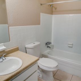 bathroom with beige walls and white shower, toilet and sink