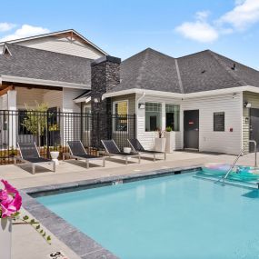 a swimming pool in front of a house with a pool