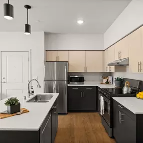 an open kitchen with white counter tops and black appliances