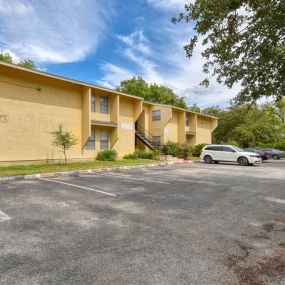 A yellow building with a parking lot in front of it