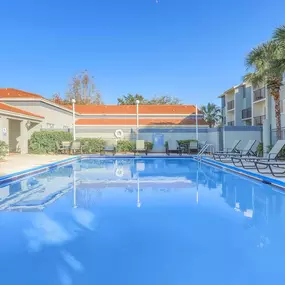 swimming pool and sundeck with lounge chairs