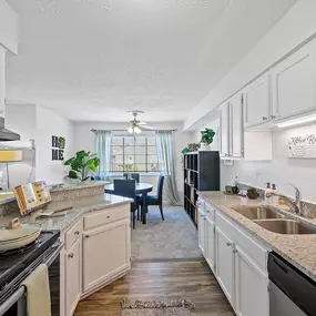 Spacious kitchen with granite counter tops and a dining room with a table and chairs