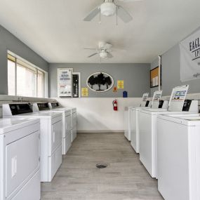 a washer and dryer laundry room with lots of white washers and machines