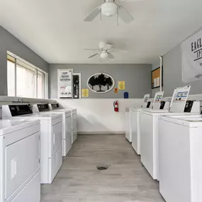 a washer and dryer laundry room with lots of white washers and machines