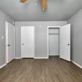 the living room of an apartment with wood floors and white walls