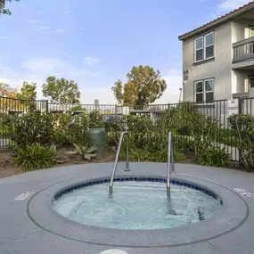 a hot tub with a fence in the background