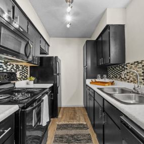 a kitchen with black cabinets and white countertops