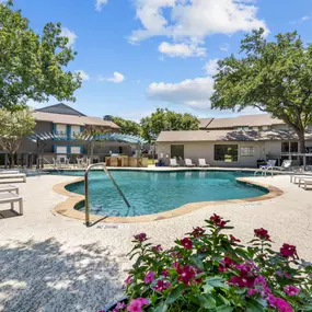 a pool with lounge chairs and trees