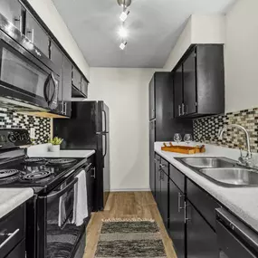 a kitchen with black cabinets and white countertops