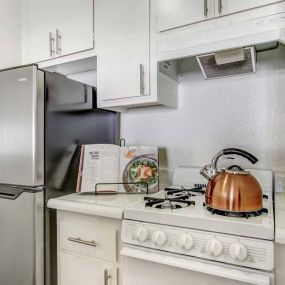 a kitchen with a stove top oven next to a refrigerator