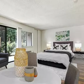 a bedroom with a table and chairs and a bed