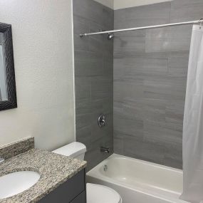 bathroom with granite countertop and tub/shower