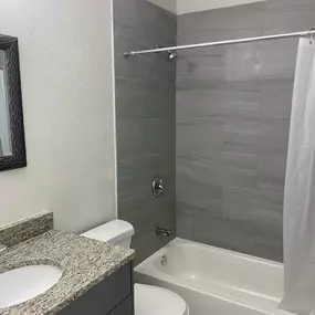 bathroom with granite countertop and tub/shower