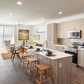 Open concept gourmet kitchens with quartz countertops and stainless steel appliances.