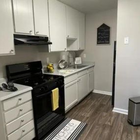 Open kitchen with amble storage and hardwood floors.