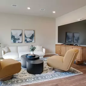 a living room with a white couch and two chairs and a television, Pinehurst Apartments, Baxter