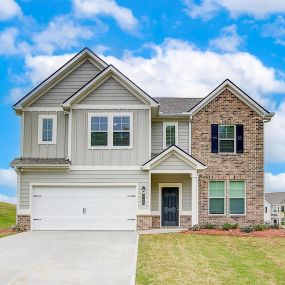 Two story home with brick and tan siding with two car garage in DRB Homes Westminster community