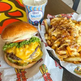 Close up image of the Original Taystee's burger and bacon cheese fries and a milkshake