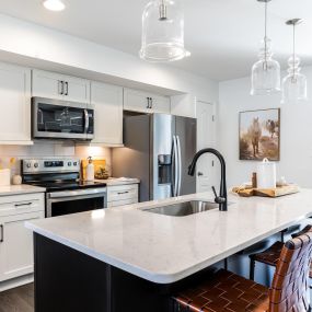 Gourmet kitchen and island with white cabinets in a townhome built by DRB Homes Pintail Landing community.