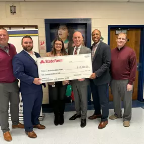 State Farm agents delivering a grant check on behalf of State Farm to An Achievable Dream school in Newport News