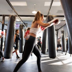 Woman hitting the bag at a TITLE Boxing Club gym